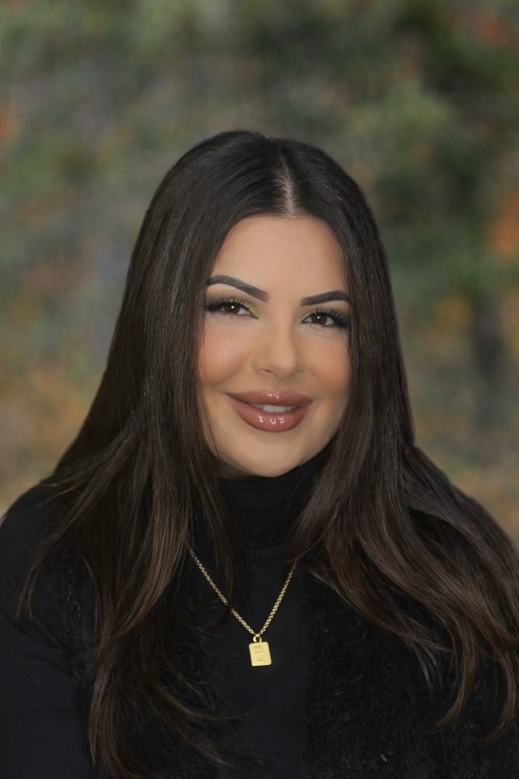 Close-up of a blooming pink water lily flower against a blurred, warm-toned background.