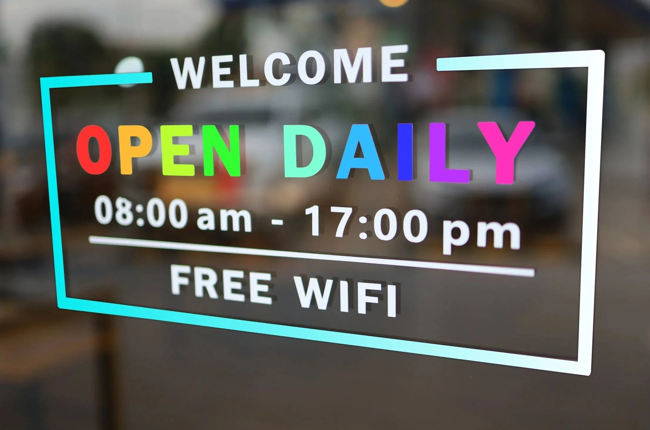 Glass door with a sign displaying business hours, saying 'Welcome, Open Daily 8:00 am to 5:00 pm, Free WiFi,' with colorful text for 'Open' and 'Daily'.