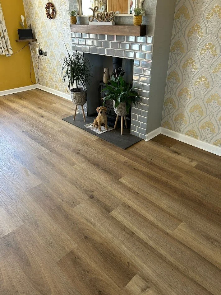 Close-up of a wooden floor with light brown planks and natural wood grain patterns.