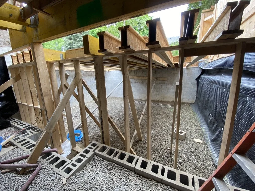 Construction site with wooden framing and cinder blocks for a building foundation.