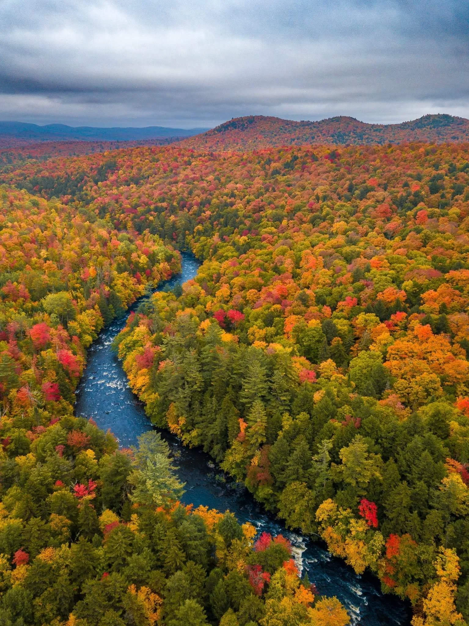 Whitewater rafting on the Hudson River surrounded by vibrant fall foliage and colorful adirondack mountains