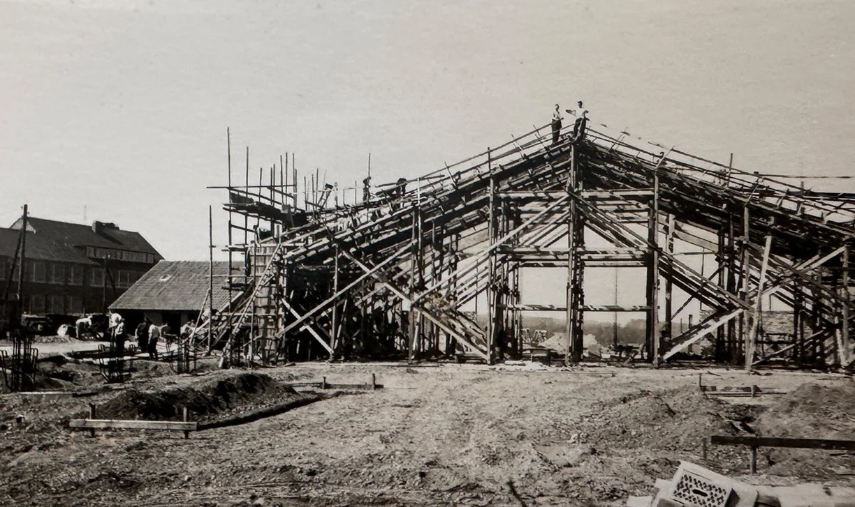 Schwarz-Weiß-Foto eines Gerüstbaus für einen Gebäudebau mit Arbeitern auf dem Gerüst