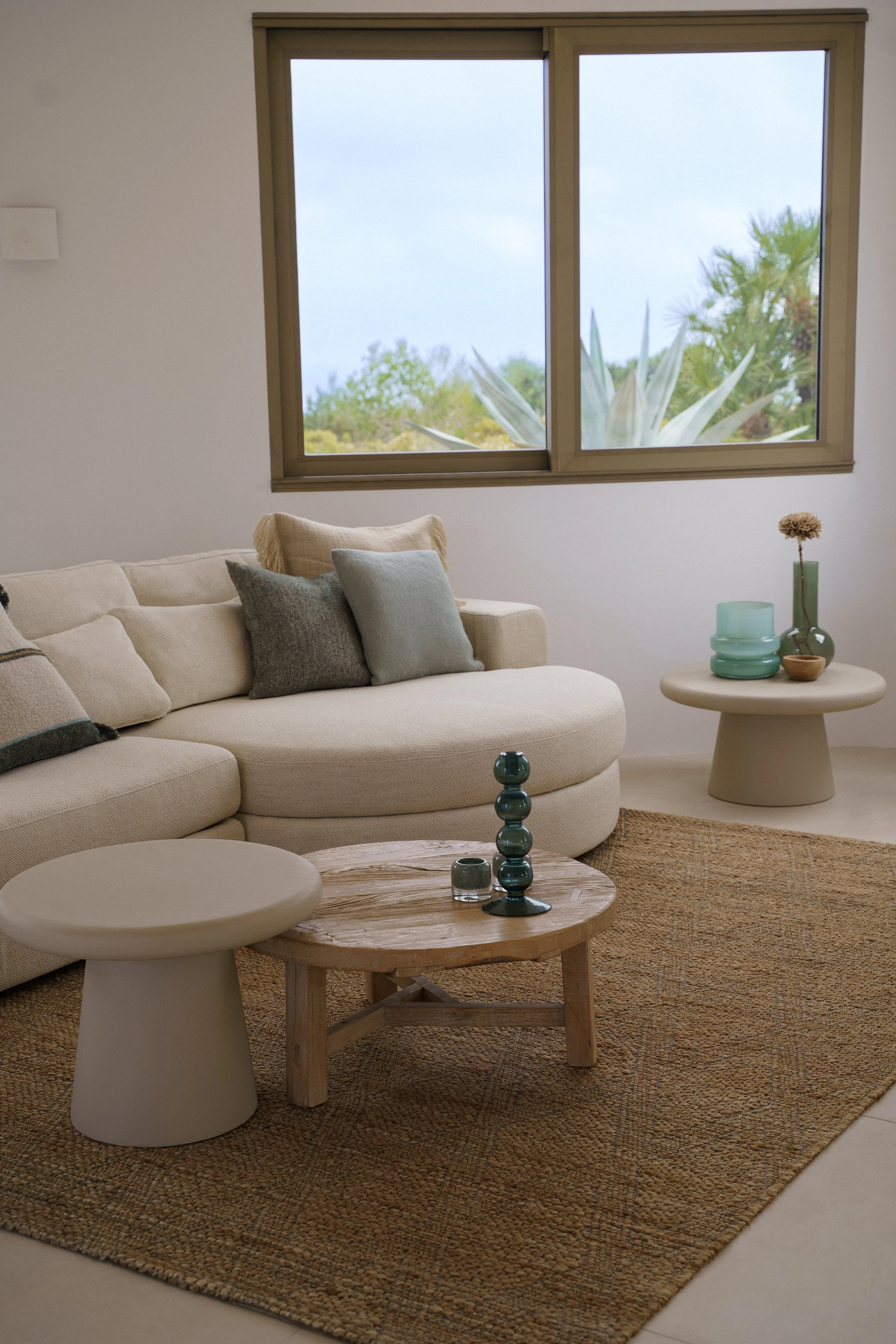 A full interior project in Javea for a client who wanted to bring the colors from the surrounding inside, blue and green cushions and decoration with light and natural furniture, couch/sofa, coffee tables and carpets 