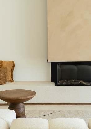 Living room with a fireplace, a wooden coffee table, and a beige sofa.