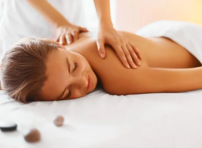Woman receiving a back massage in a spa or massage therapy setting.