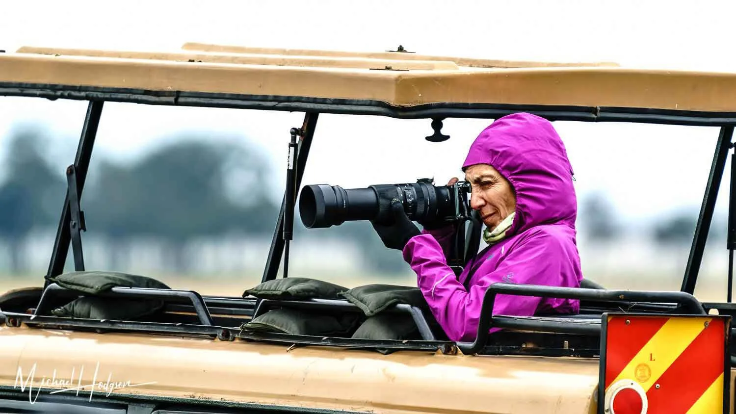 Therese Iknoian with a rain jacket and gloves trying to stay warm and dry on her African safari.