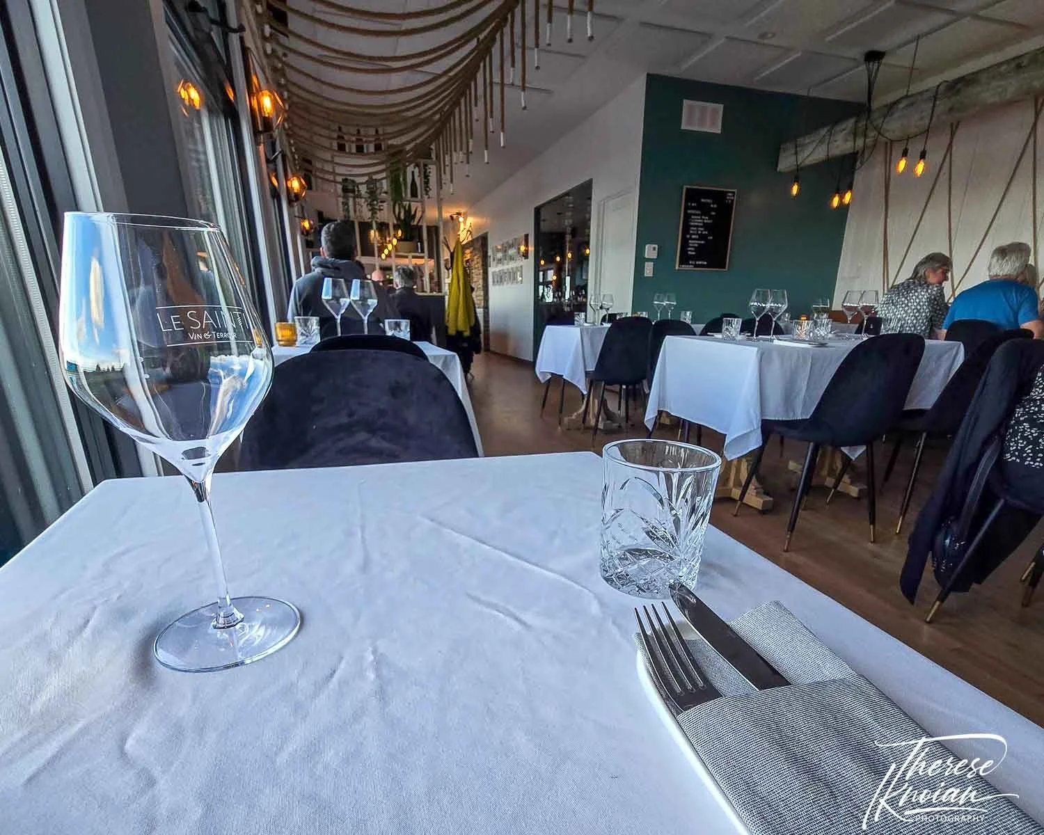 A table and wine glass inside Le Sainti Restaurant Charlevoix