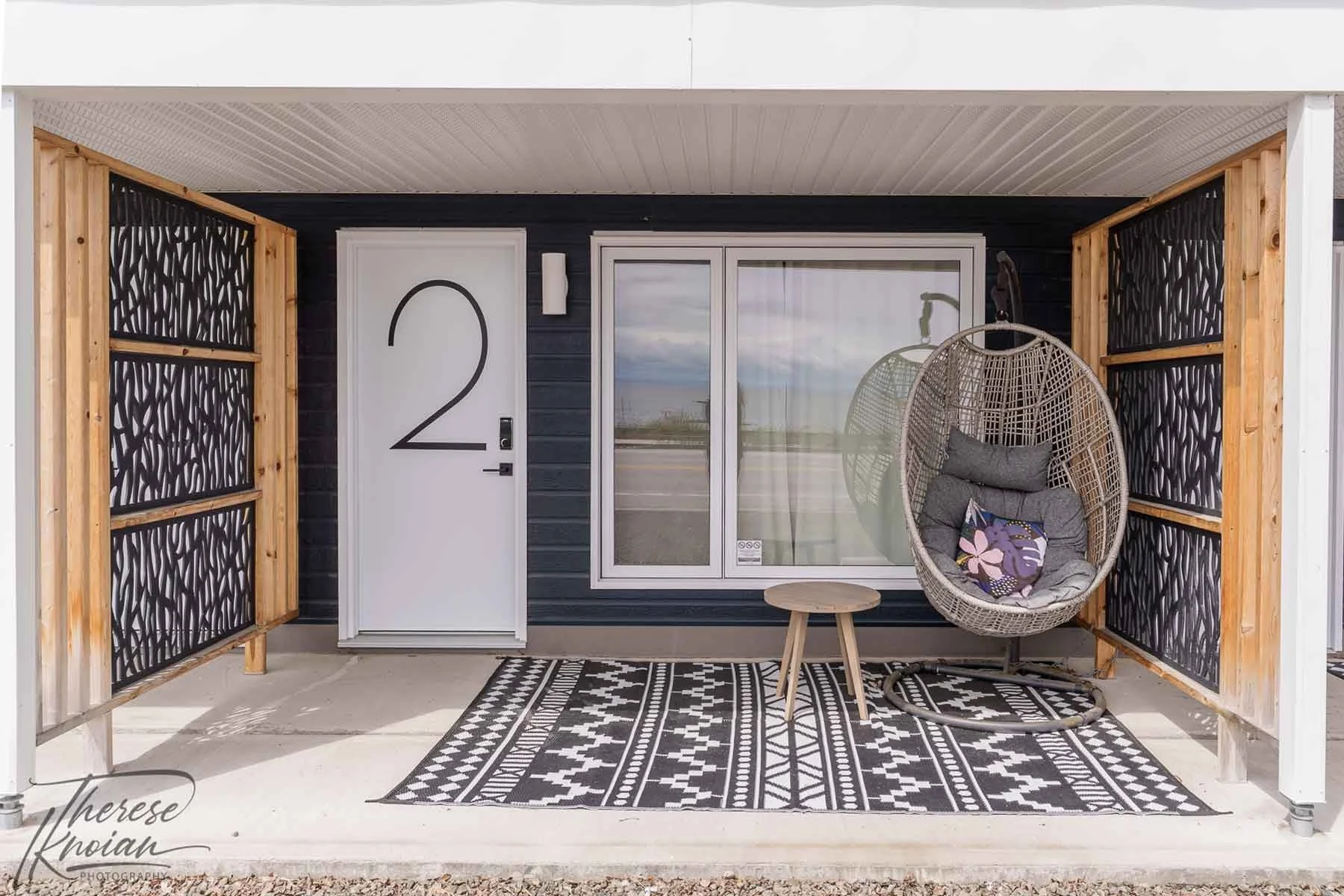 Entrance and patio with hanging chair to Room 2 at Le 362 retro roadside motel in Charlevoix