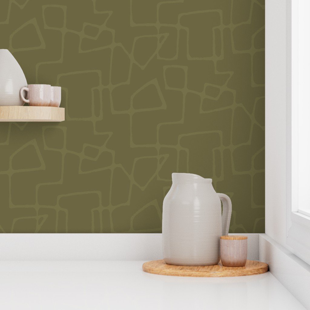 A white ceramic pitcher and a small cup on a round wooden tray, placed on a white windowsill with an olive green wall with a tone-on-tone mid-century modern line pattern in the background.