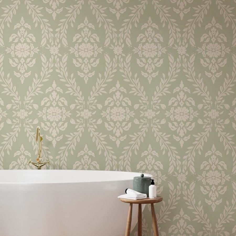 Bathroom with a free-standing bathtub, wallpaper with a pale green floral damask pattern, small wooden table with toiletries, and a gold-colored faucet.