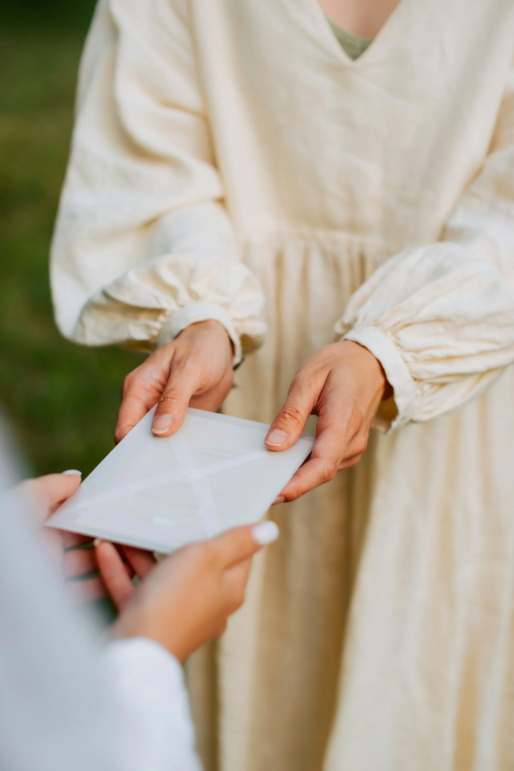 Bride handing tip envelope to wedding vendor