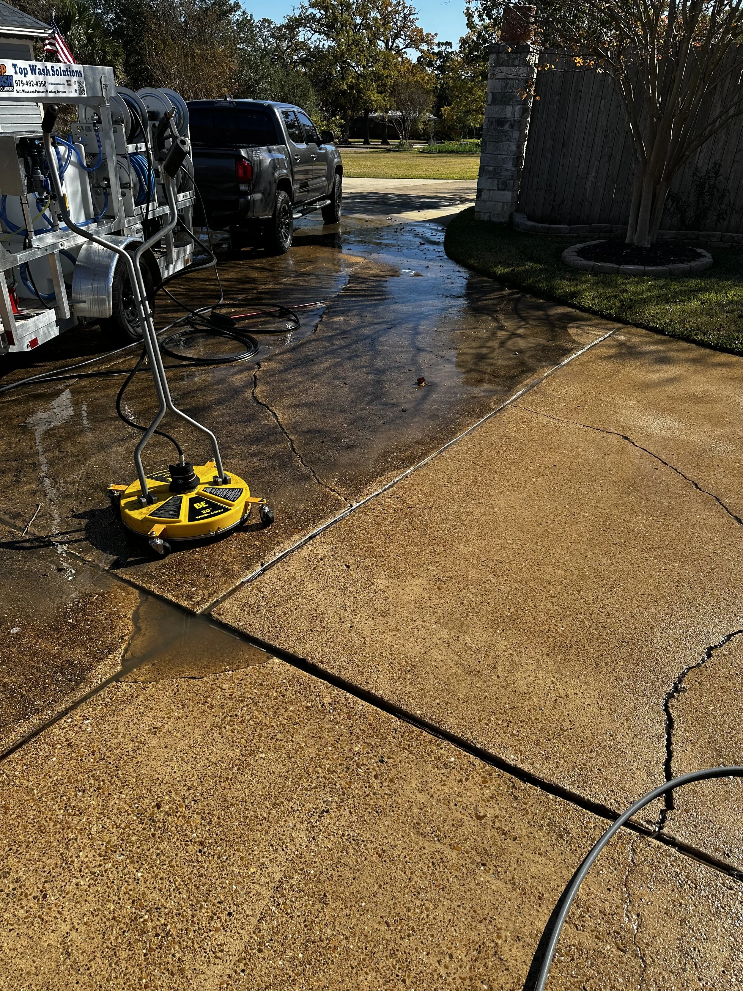 Person using a power washer to clean the siding of a house.