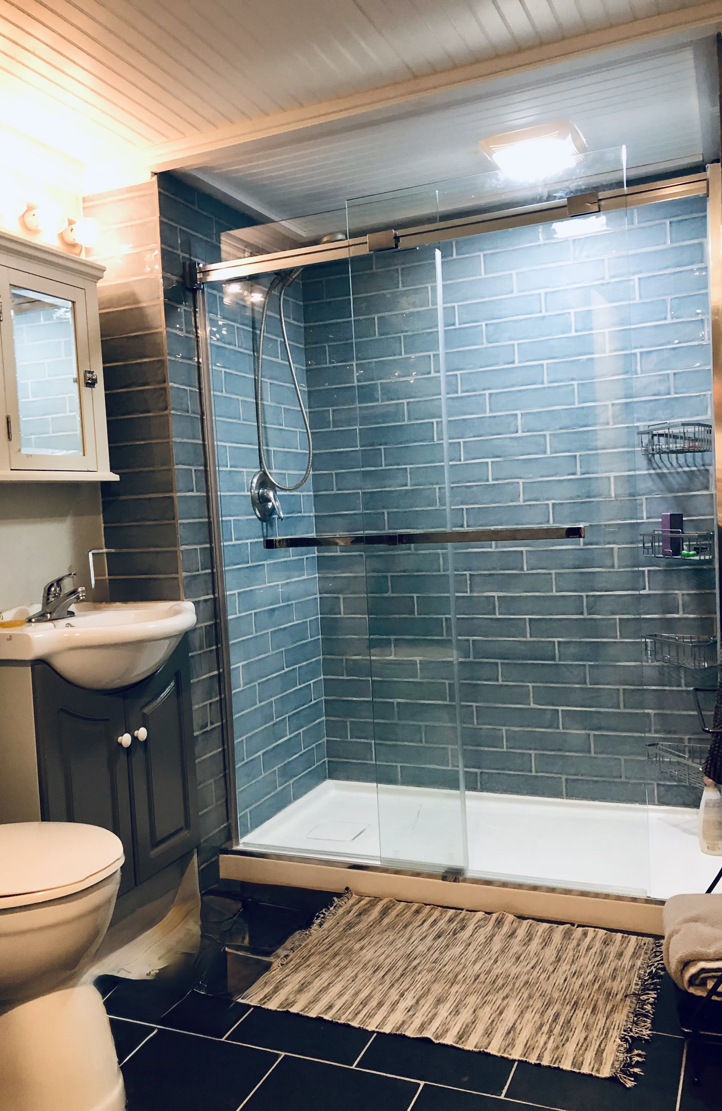Basement suite bathroom: New tile shower, pan, and glass sliding doors. New tile flooring. New ceiling and lighting, all wet-space rated.