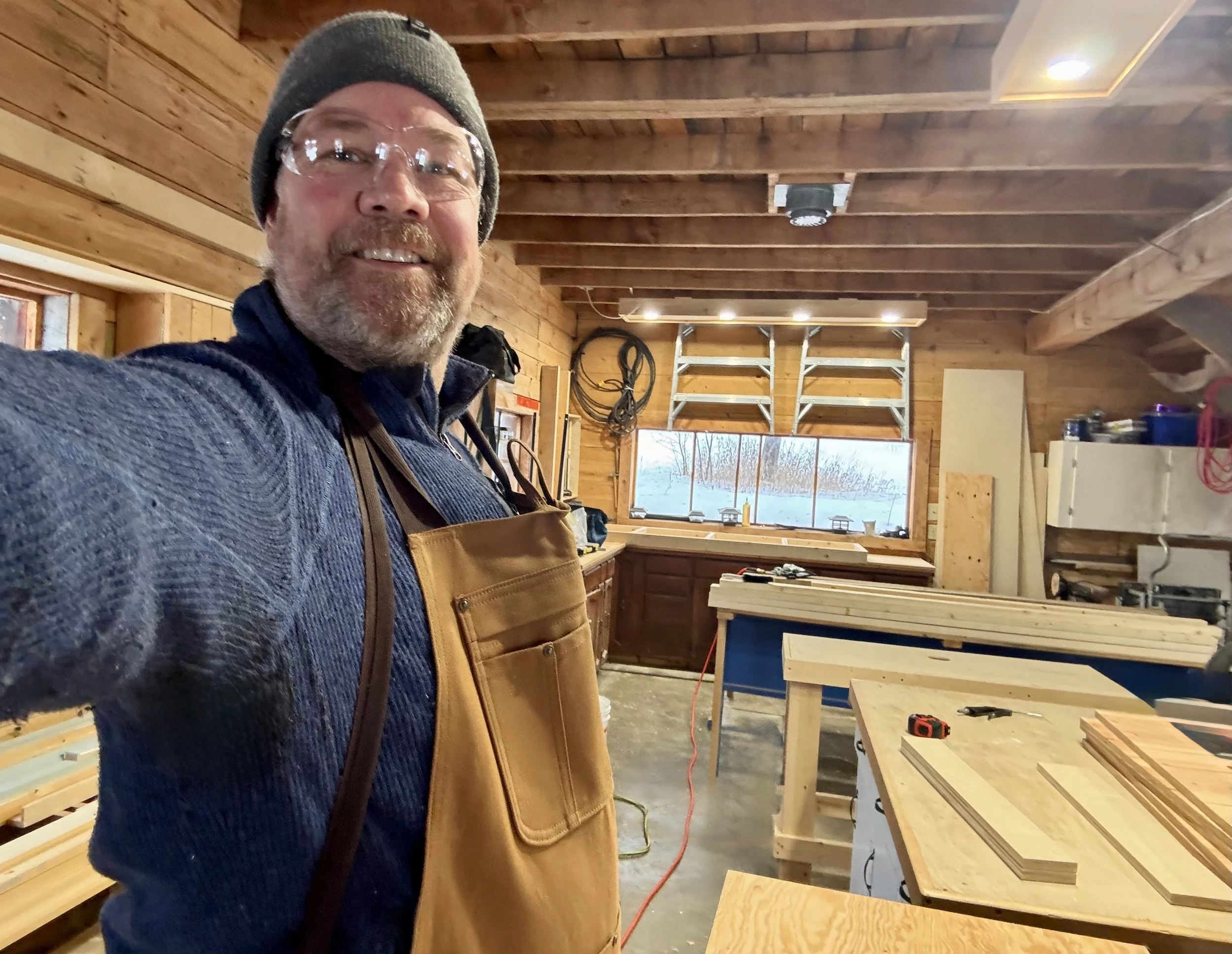 Mark standing in his shop taking a photo of self.