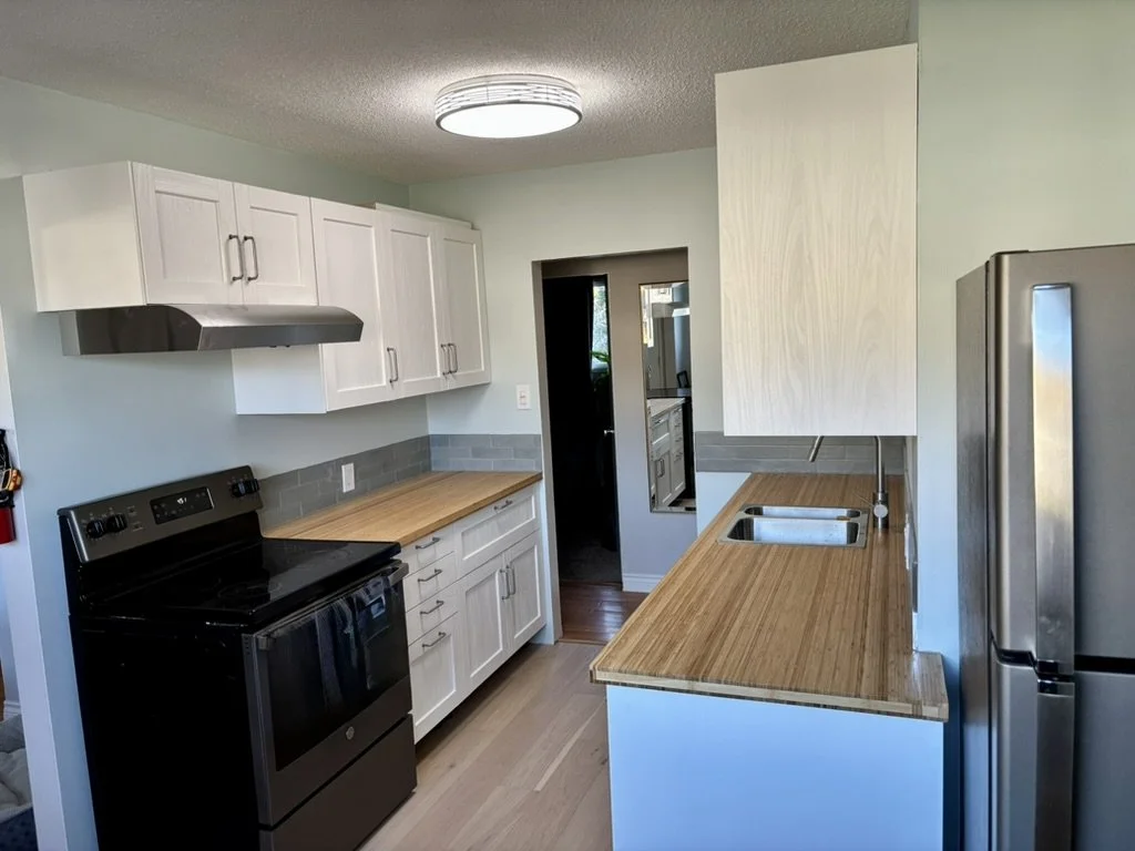 New prefab cabinets and counters with engineered hardwood flooring damp-rated for kitchen use.
