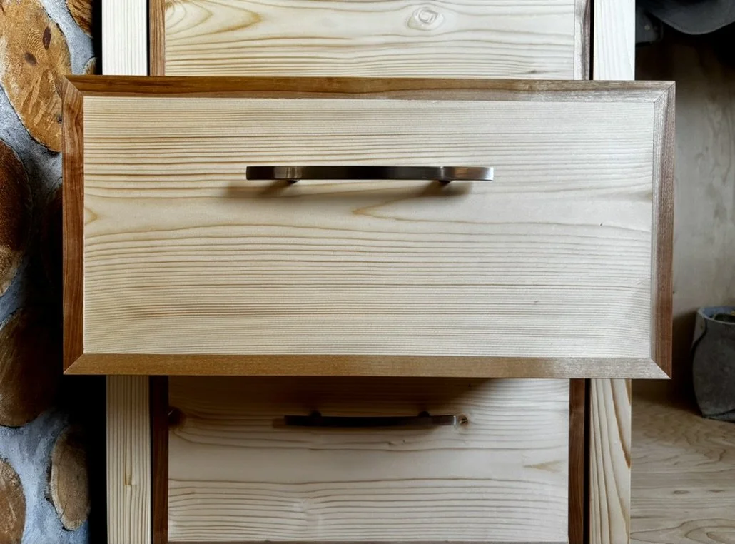 Close up of draw front with contrasting white pine with walnut border finished in a natural oil and wax rub.