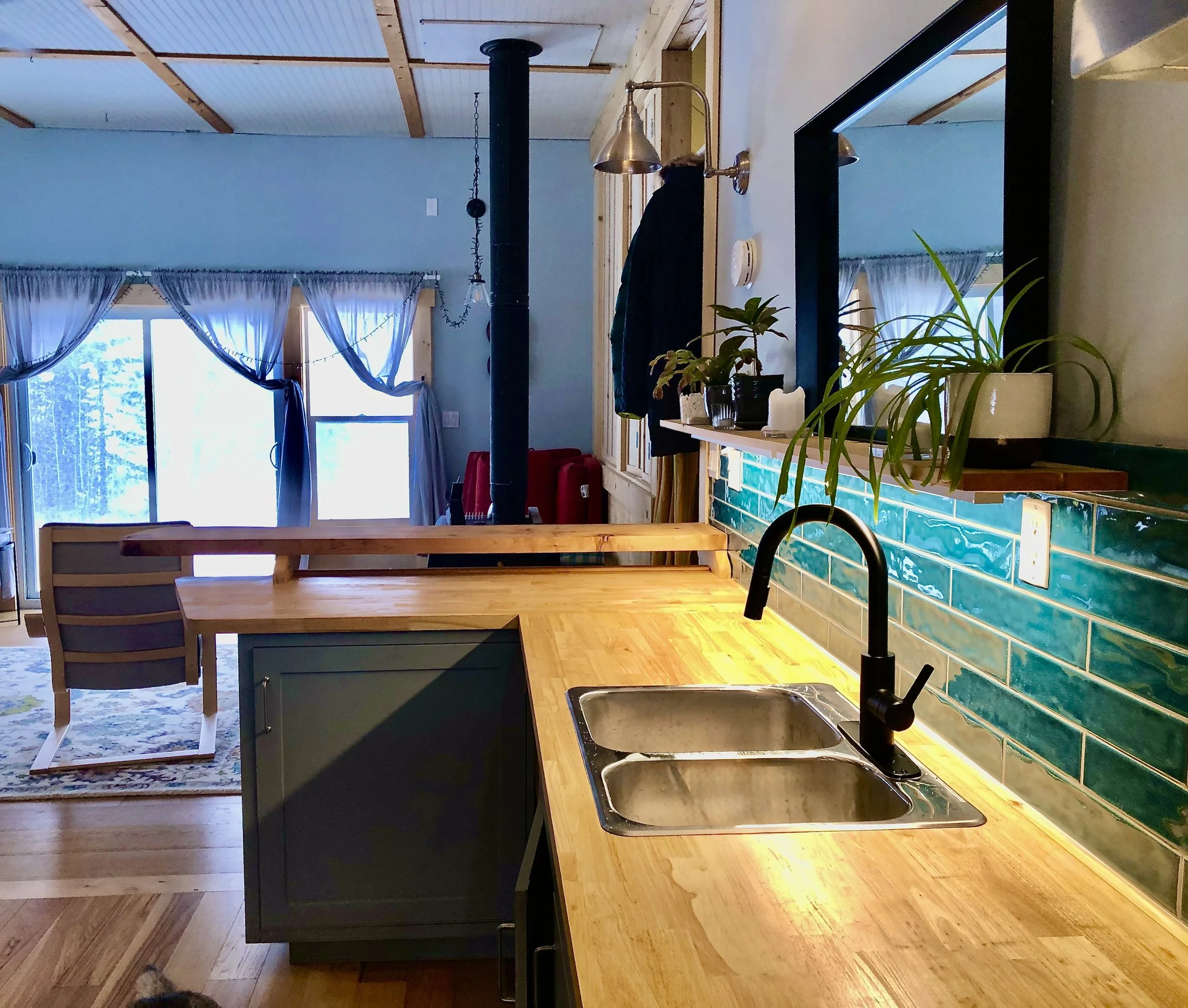 Custom kitchen with butcher block counters, live edge bar, tile backsplash, and yellow cedar trims and shelves. Natural and foodsafe citrus oil and beeswax finish. Engineered hardwood flooring damp-rated.