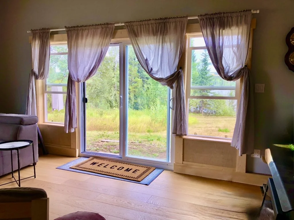 Living room: Replace single smaller window unit with new casement windows and double sliding doors. Install wide-planked engineered hardwood flooring throughout. Reinforce the framing for increased lateral stability and trim out in natural pine with 