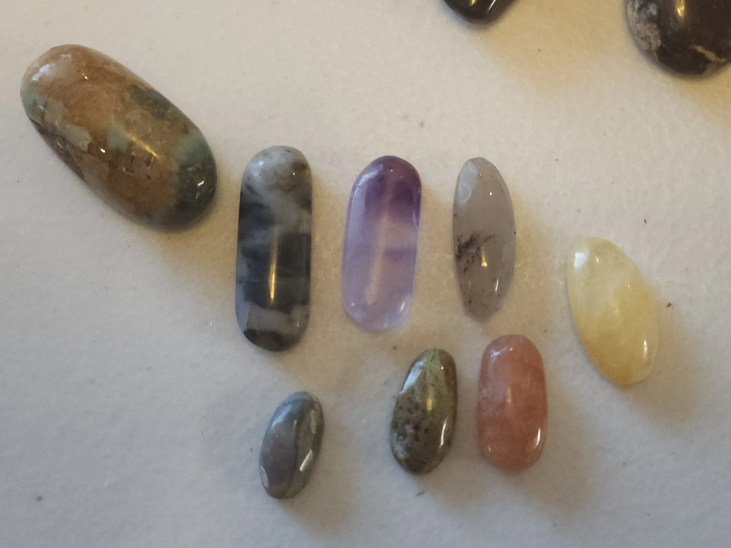 Collection of ten assorted oval hand-cut and polished gemstone cabochons ready for jewelry.  Cutting/polishing services available.