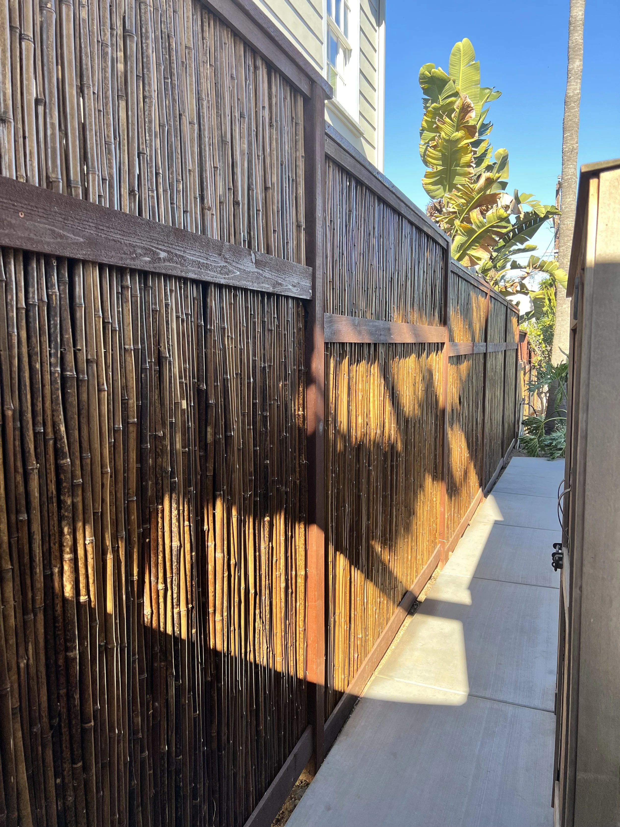 Privacy fencing featuring stained bamboo and Pressure treated framing with stained Cedar trim in Ocean Beach, CA 92107