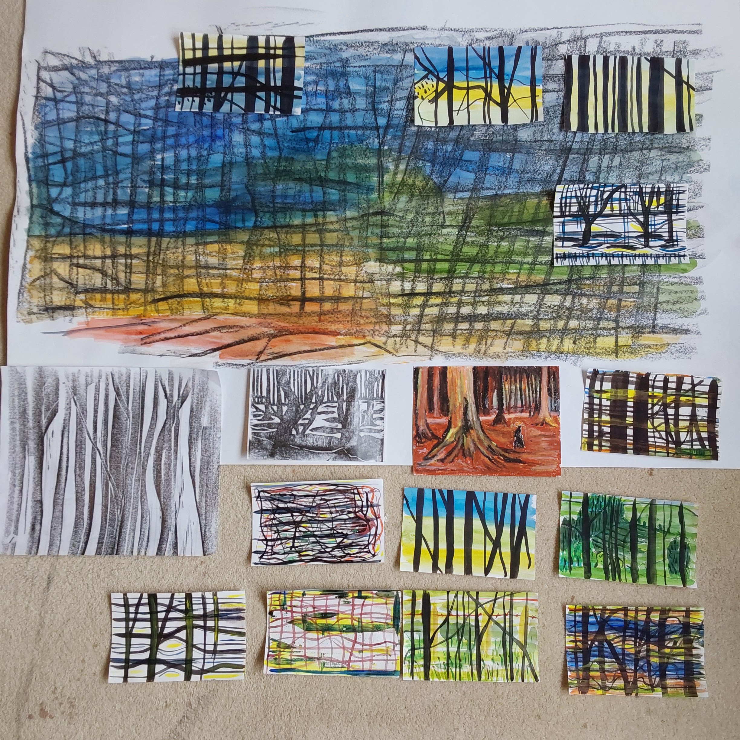 Collection of colorful and monochrome artistic drawings and paintings of trees and forests displayed on a wall. The artworks depict various styles, including abstract, realistic, and impressionistic forest scenes.