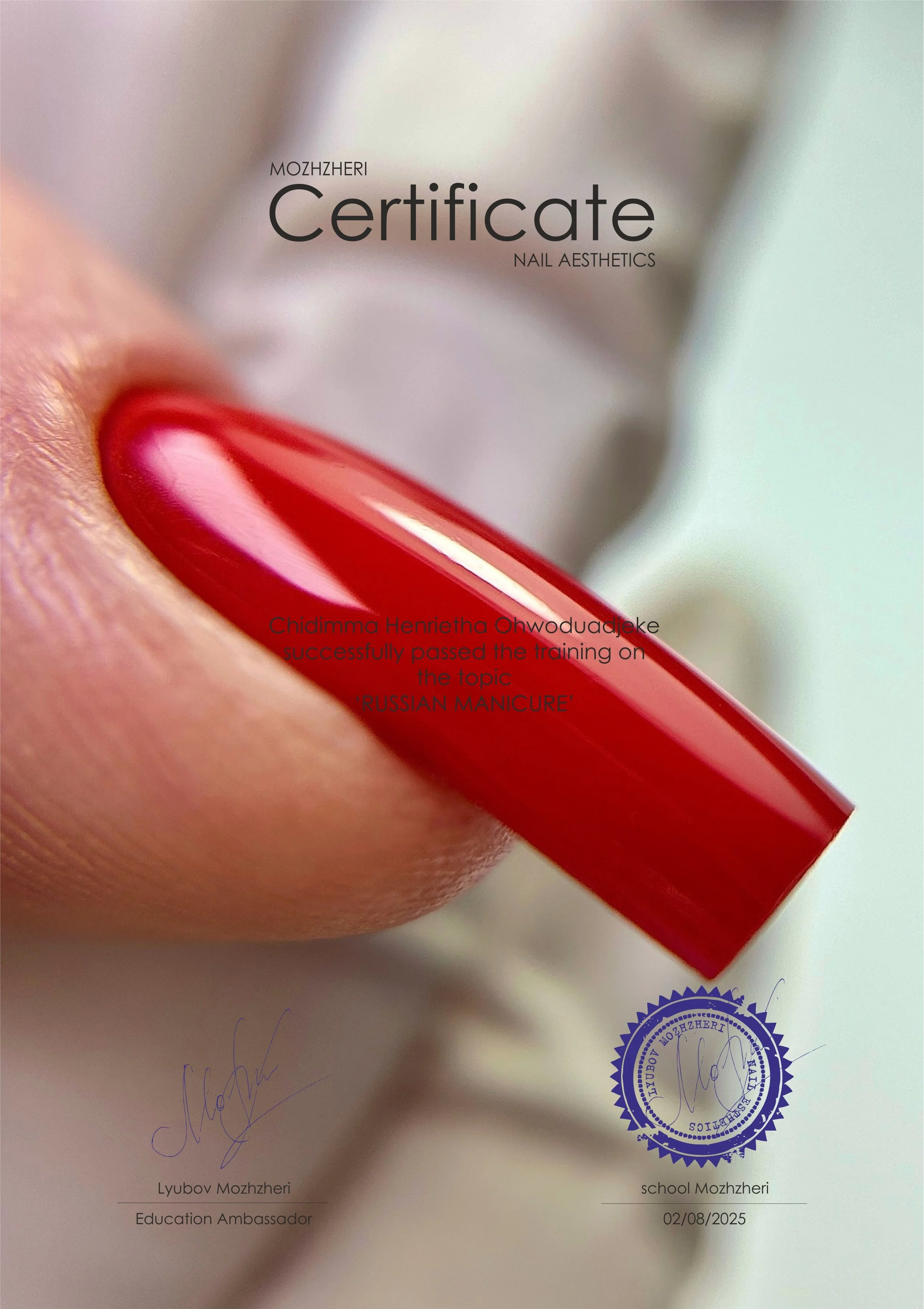 Close-up of a certificate for nail aesthetics awarded to Lyubov Mozhzeri, with a red-painted fingernail in the foreground, and a blue official stamp at the bottom right.