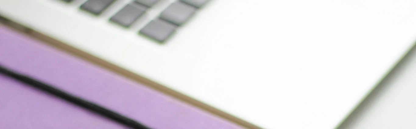 immagine orizzontale, si intravede un laptop argento e un'agenda viola chiaro, scopri perché Pinterest è importante per la tua newsletter