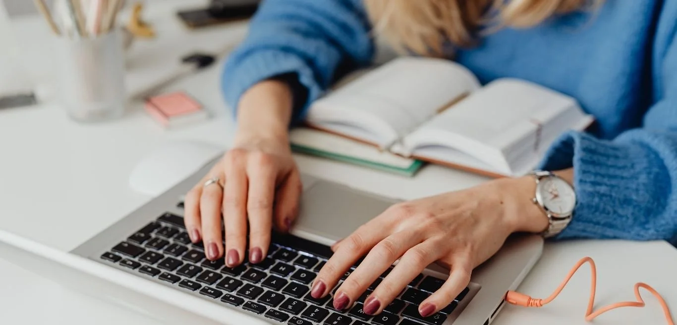 inquadratura ravvicinata delle mani di una donna  che scrive al computer di un home office luminoso e ordinato. Vuoi trasformare Pinterest in un motore di traffico?Clicca per leggere la guida completa sul mio blog.