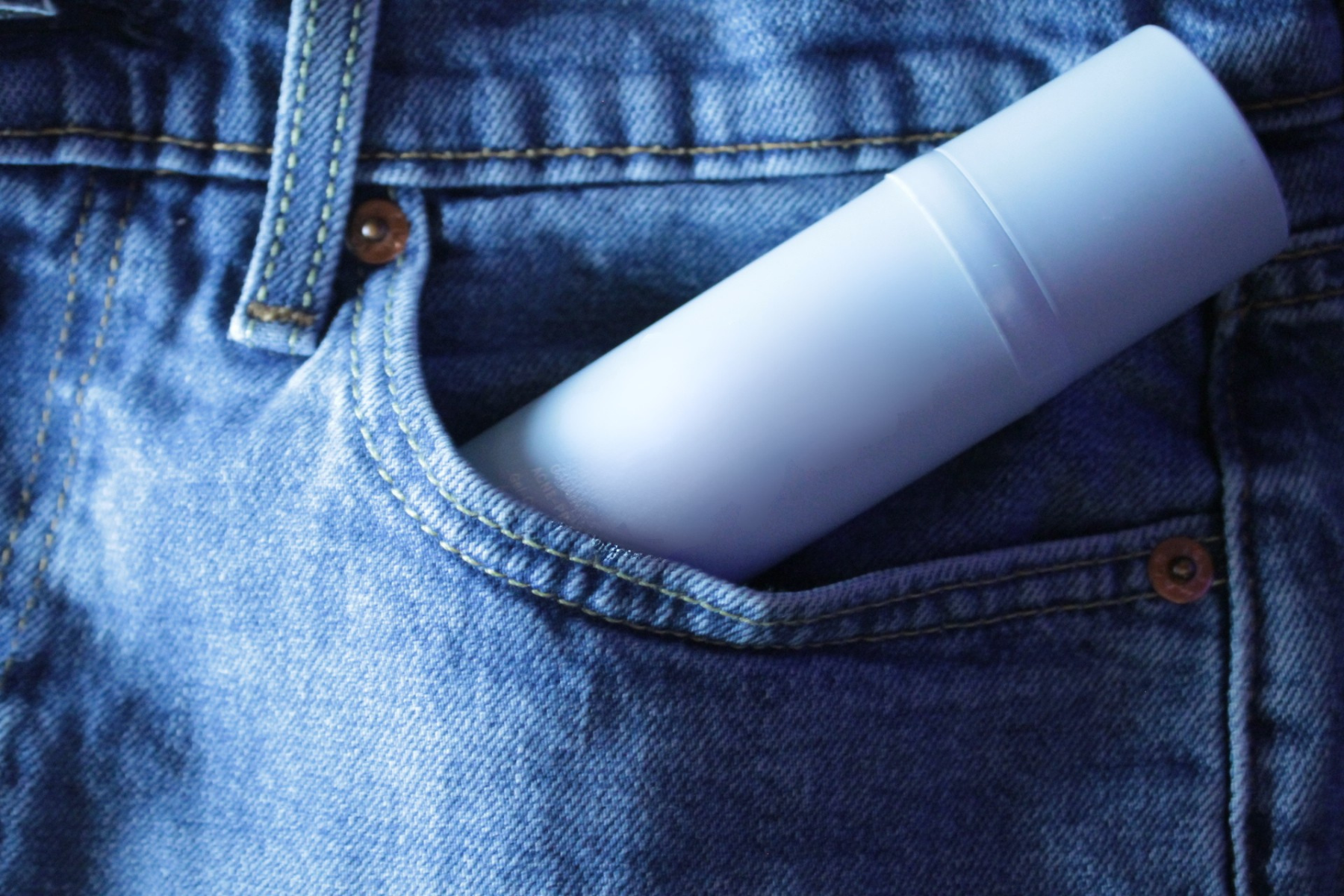 Une bouteille sans marque dans une poche de jeans