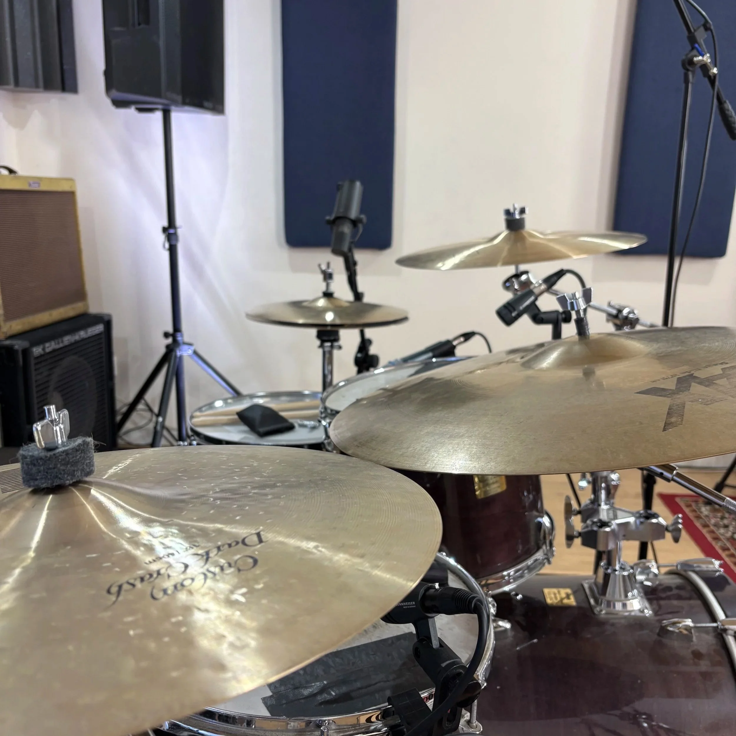 A drum set in a music studio with cymbals, microphones, and acoustic panels on the wall. Recording at Generation Studios, Maidenhead, for Lewis Cole's promotional work.