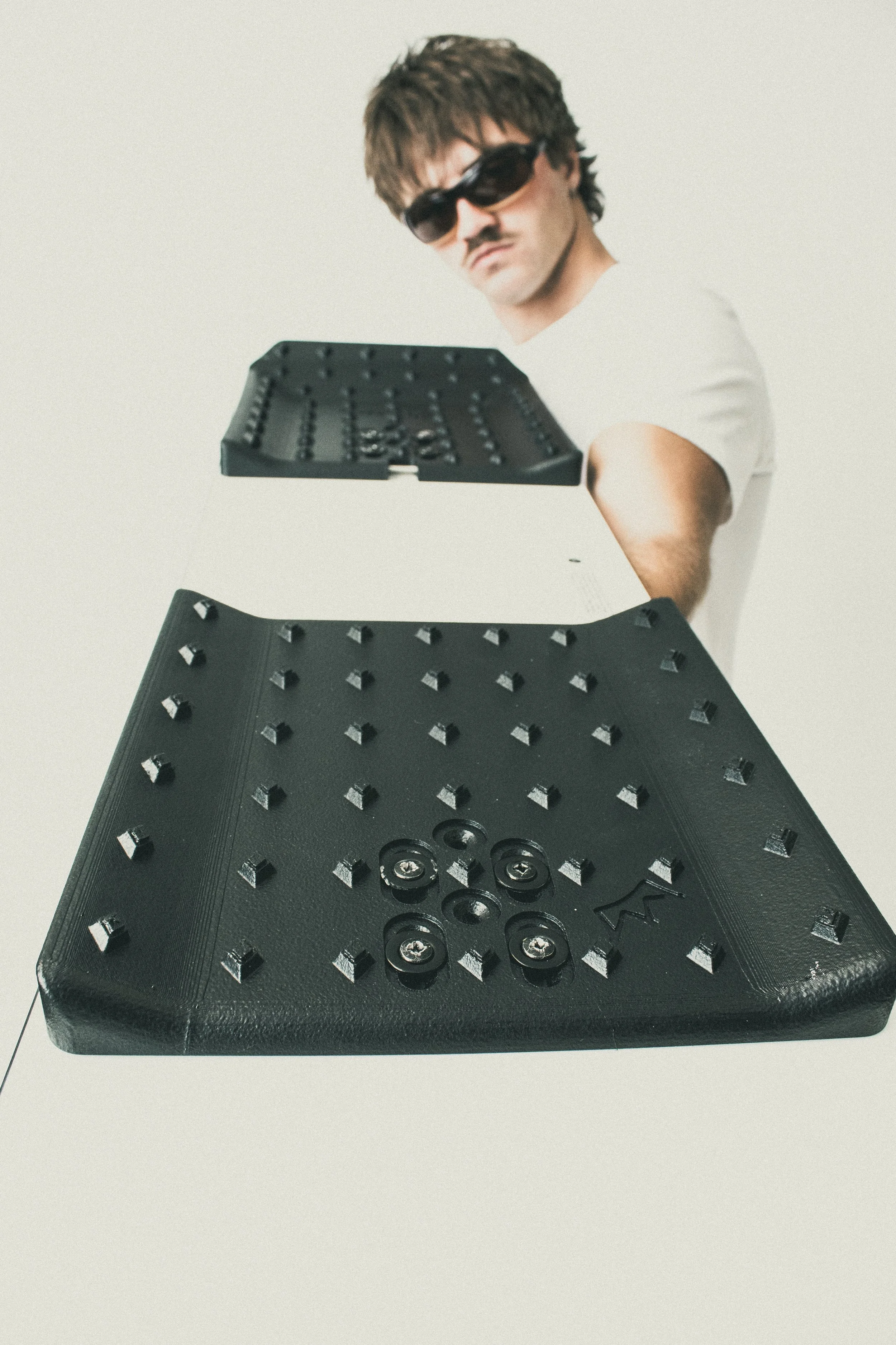 Rider holding the front and rear Black Solid Pads toward the camera, showing surf-shaped kick and traction