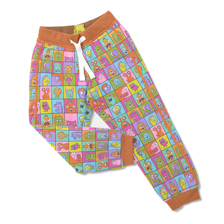 A brightly colored illustrated pattern of monster in individual boxes mocked up on children's jogger pants