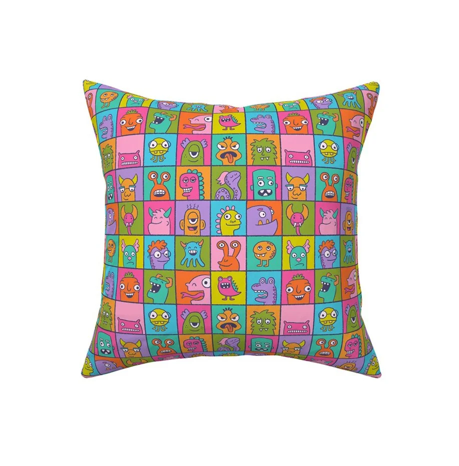 A brightly colored illustrated pattern of monster in individual boxes mocked up on a throw pillow