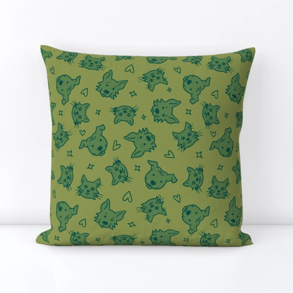 Mock-up of a pillow with a pattern featuring a light green background and illustrated faces of two dogs and two cats in darker green