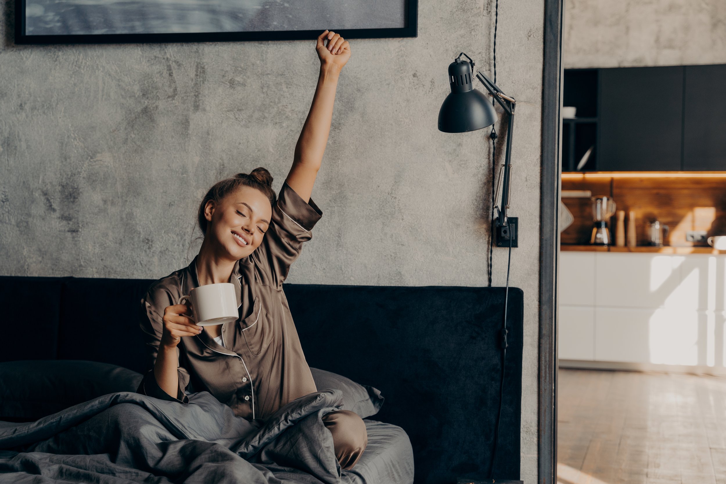Woman waking up refreshed in bed, illustrating improved sleep quality, recovery, and the effects of a well-designed sleep supplement stack.