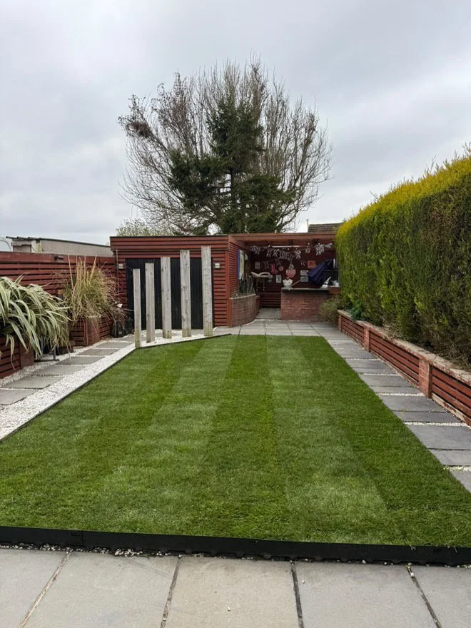 Rectangular natural lawn between paved paths and raised planting beds