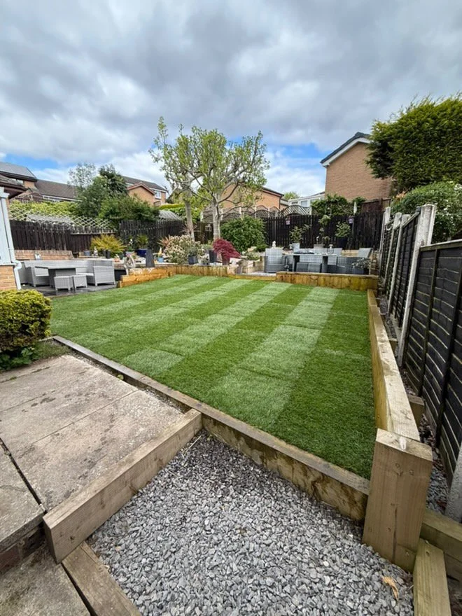 Newly laid natural lawn with sleeper edging in a landscaped garden