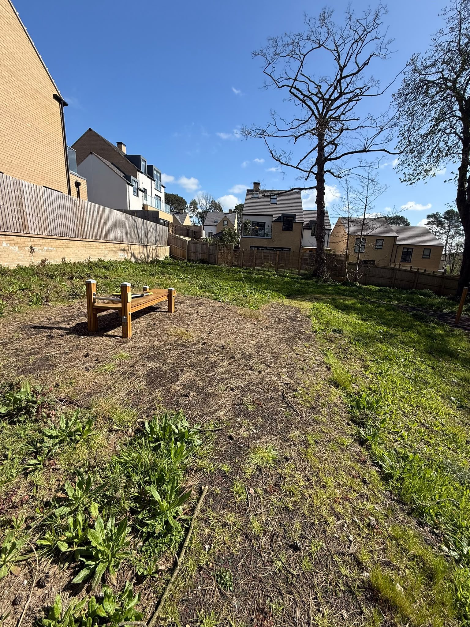 Sloping grassed habitat area with mature trees and nearby housing