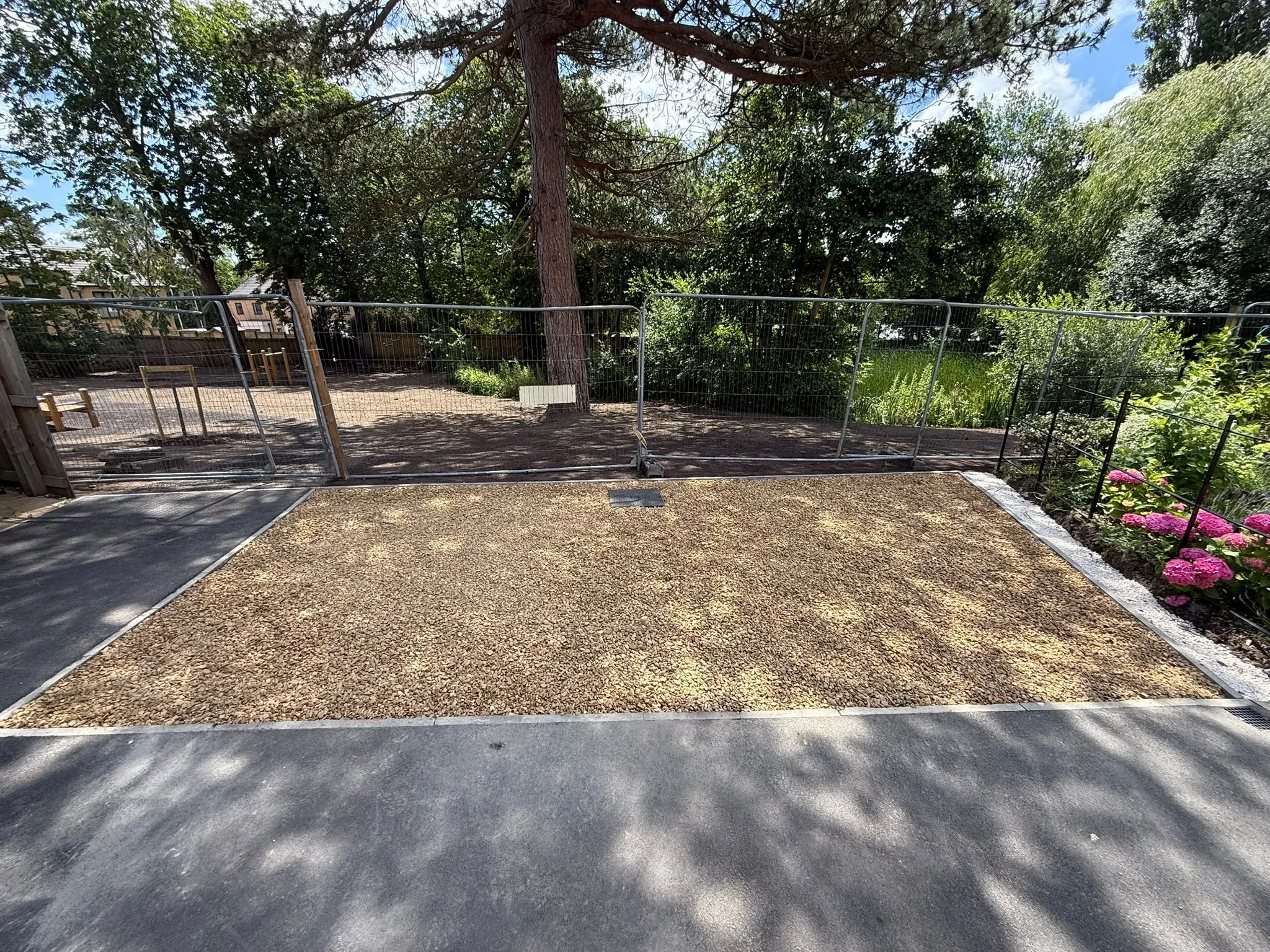 Completed gravel surface beside temporary site fencing