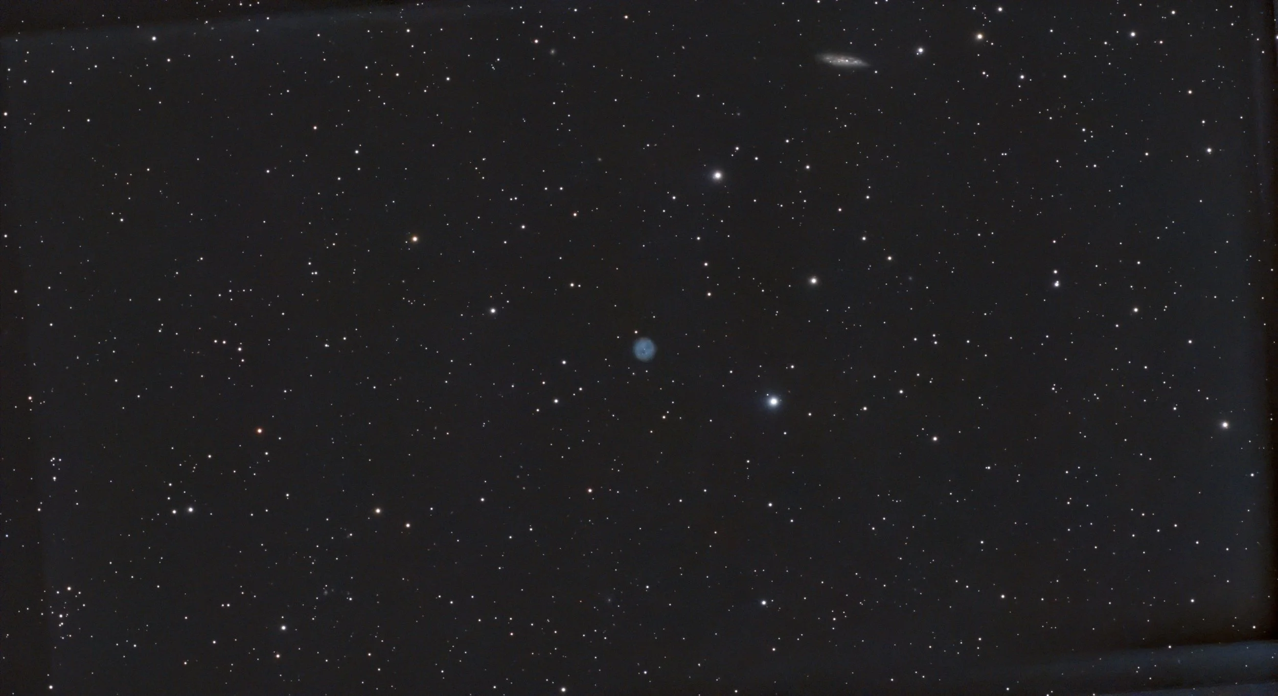 Owl Nebula (M97), a planetary nebula. Its faint circular structure is visible within the surrounding star field, with the edge-on galaxy M108 appearing in the same field.