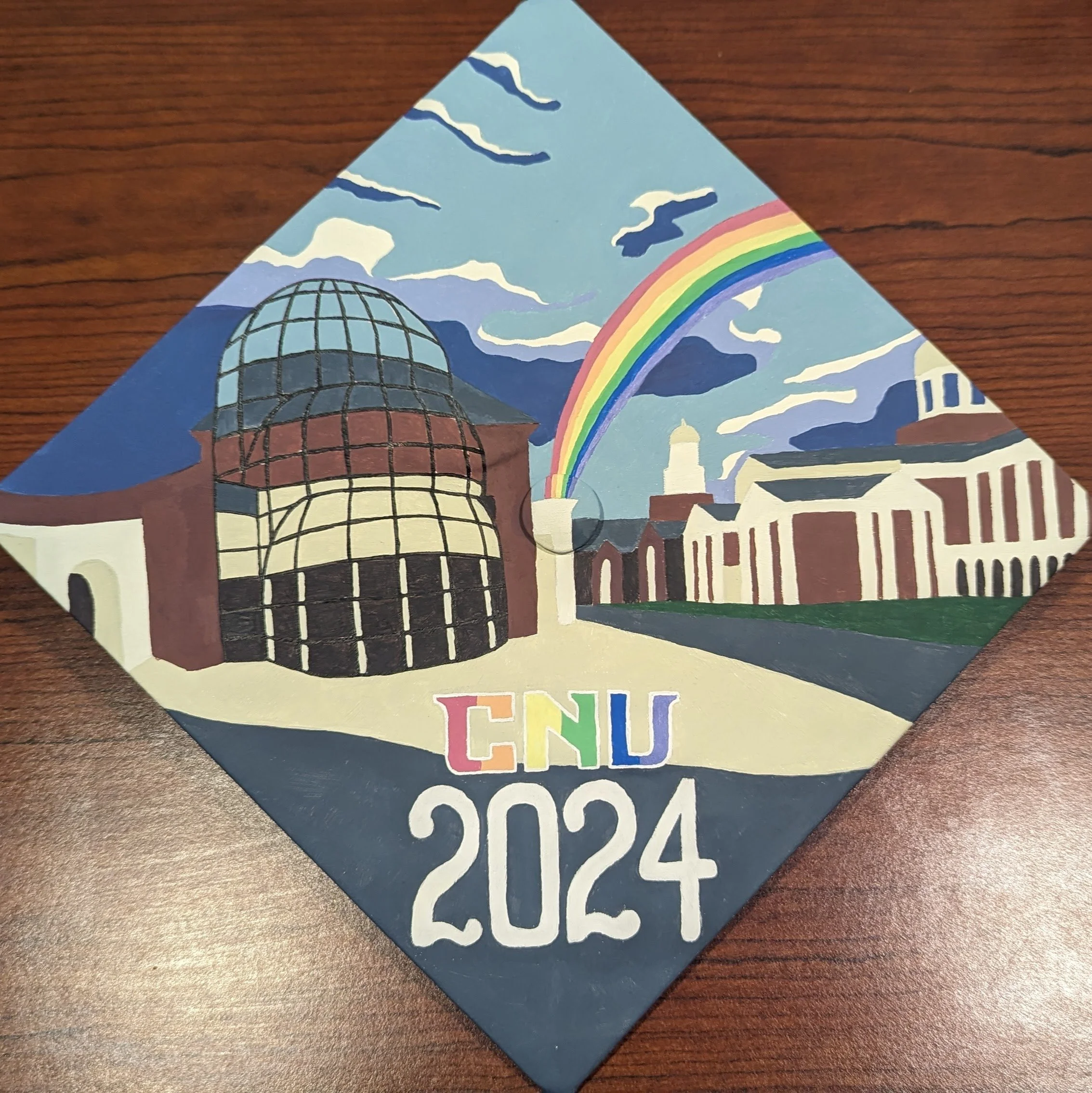 Graduation Cap, 05/2024 Acrylic on fabric. To celebrate my graduation from CNU, I painted my cap with a picture of the Torggler Fine Arts Center and Trible Library.