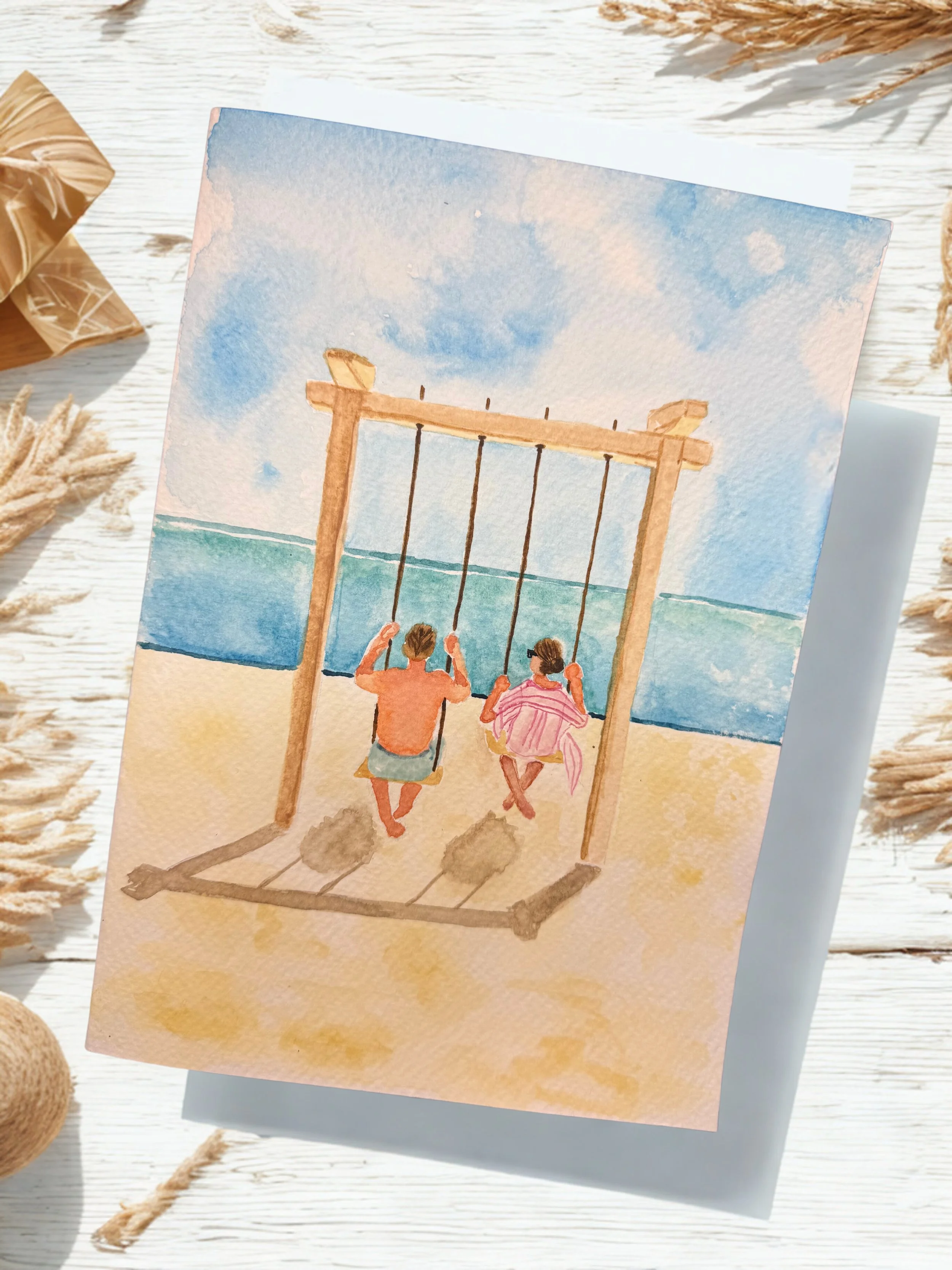 Watercolor painting of a boy and girl sitting on a swing, looking at the ocean under a partly cloudy sky.