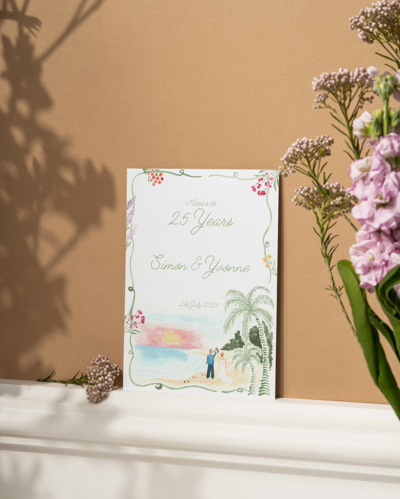 A wedding anniversary invitation card with hand-painted beach scene, floral border, and text celebrating 25 years of Simon and Yvonne on July 21, 2025, surrounded by pink and purple flowers.