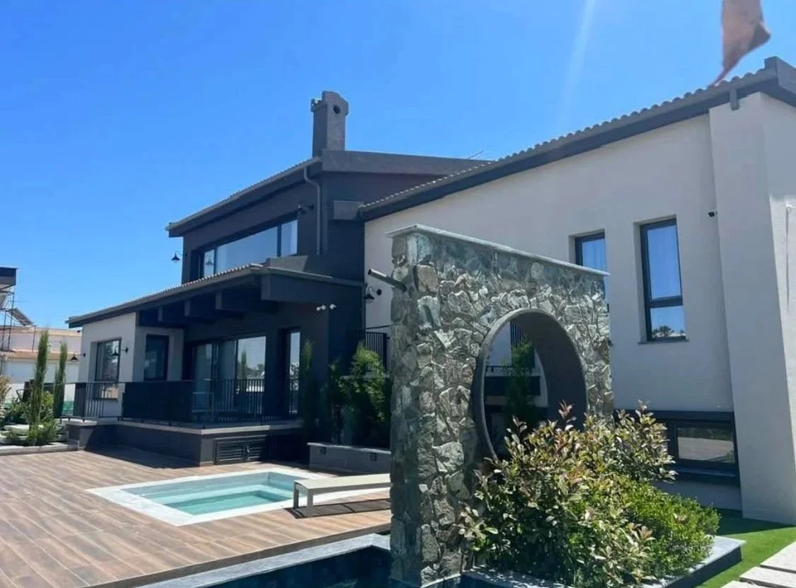 Modern house with pool and stone archway in a backyard