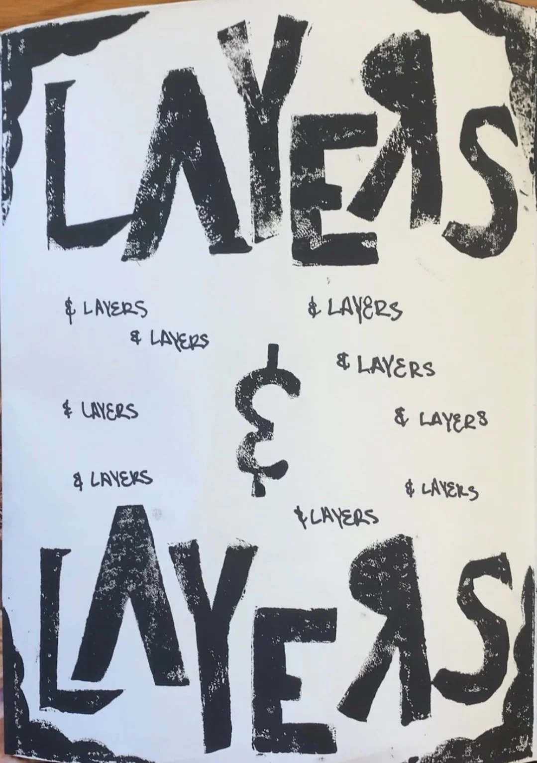 Handmade poster with the words 'LAYER$ LAYERS' written in large, distressed black letters at the top and bottom. The middle of the poster features a dollar sign ('$') in black. Surrounding the dollar sign are multiple handwritten repetitions of the p