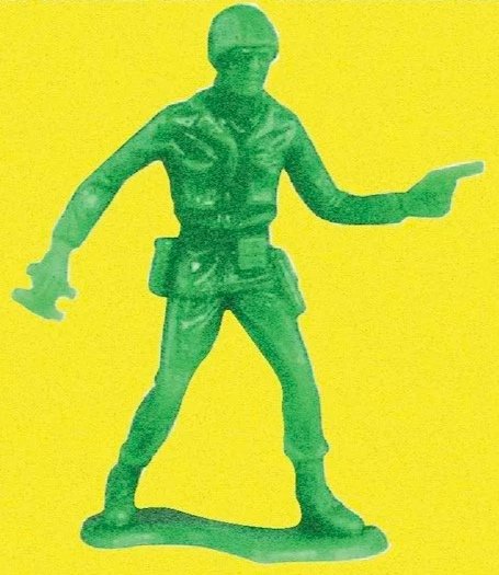 Green toy soldier with a helmet, holding a rifle in one hand and a paper or map in the other, on a yellow background.