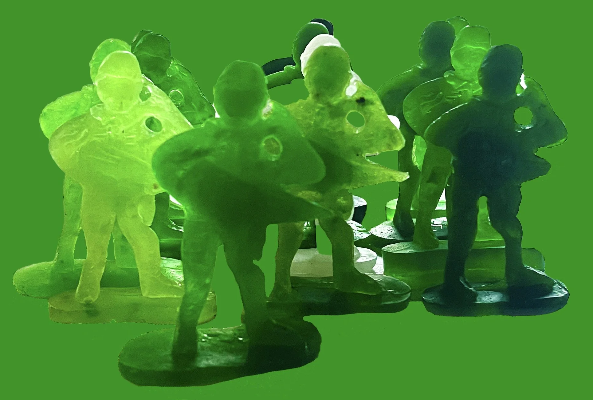 A group of small, colorful plastic toy soldiers standing on a green background.