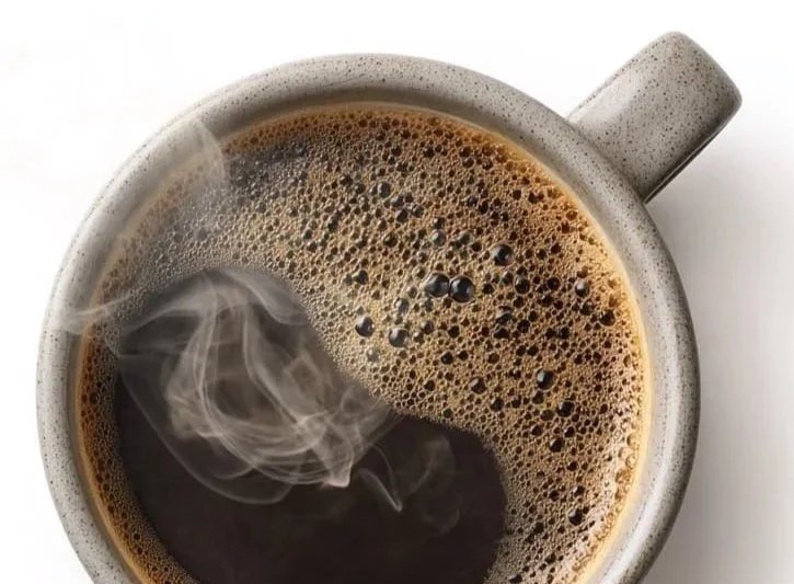 Cup of black decaf coffee with steam rising
