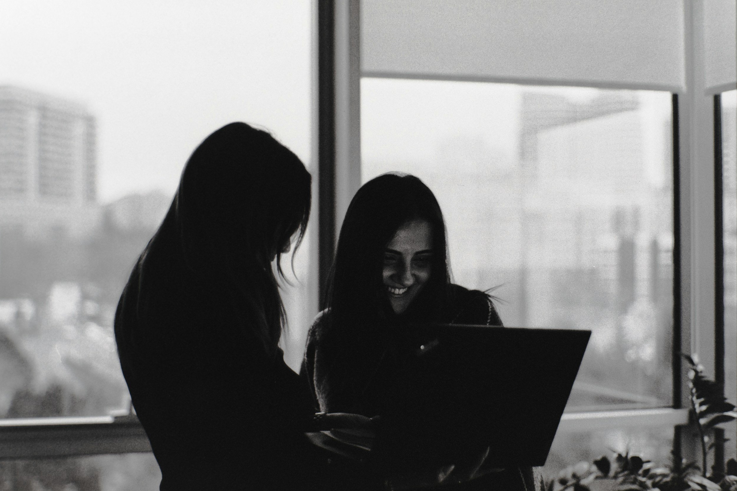 Two women reviewing work on a laptop.