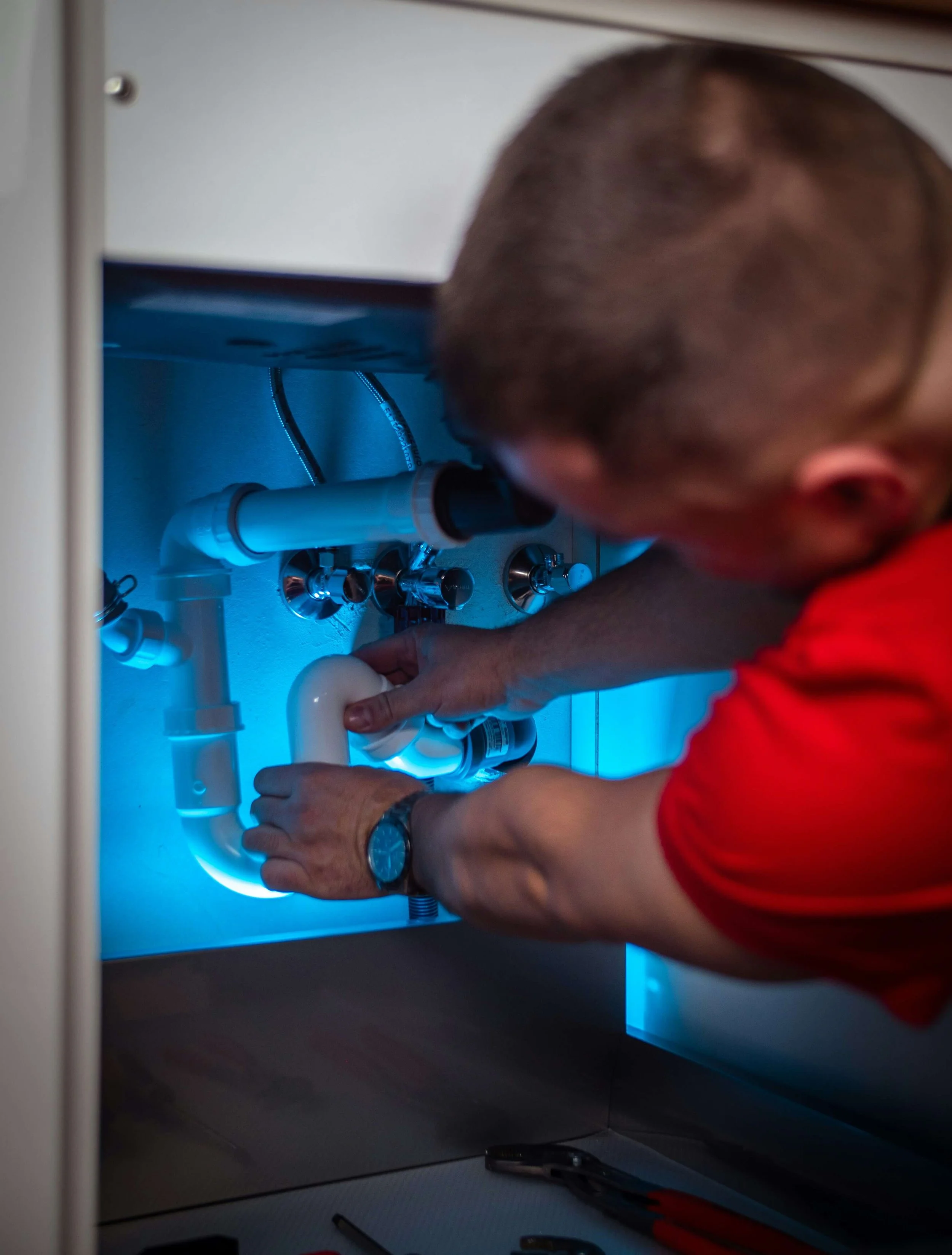 A plumber fixing a sink after Hermleigh Digital helped him better market his services and get more leads in the Richmond, VA area.